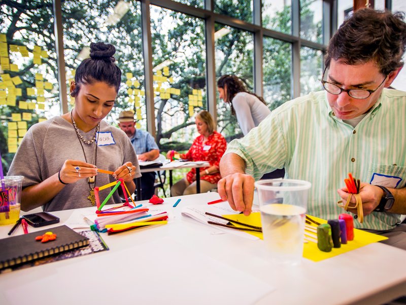 People constructing objects with building blocks People constructing objects with building blocks